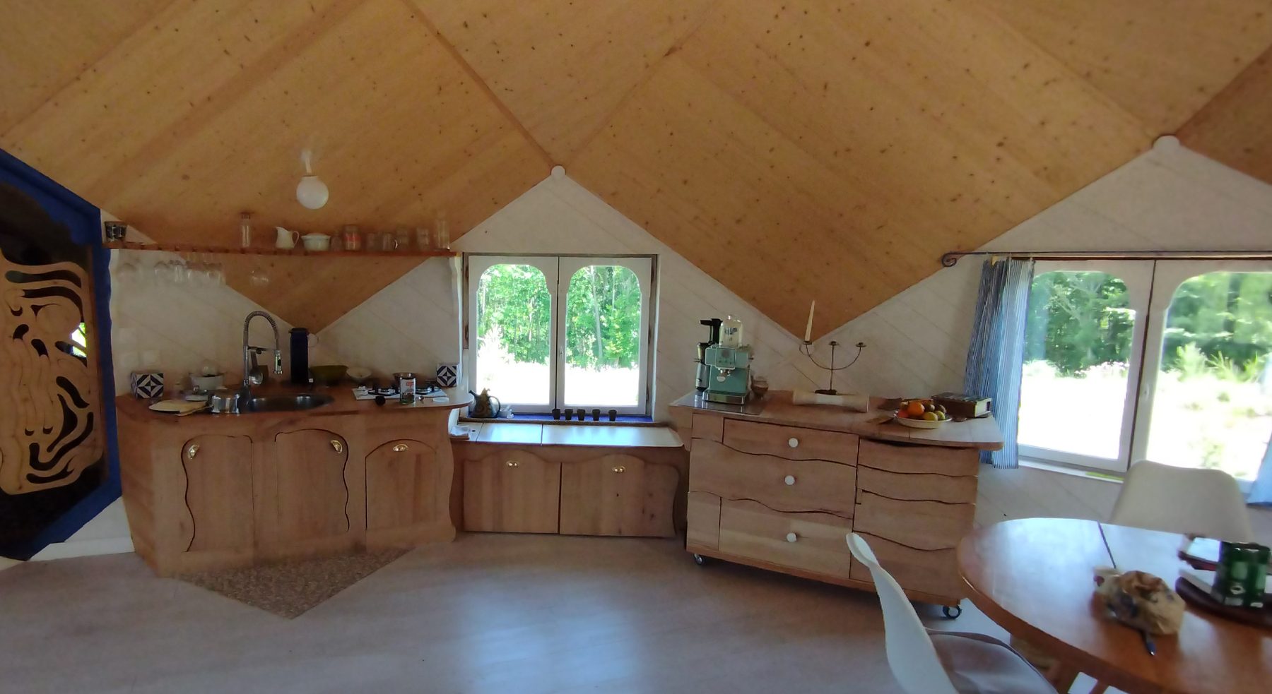 Intérieur du dôme : cuisine et charpente en bois apparente
