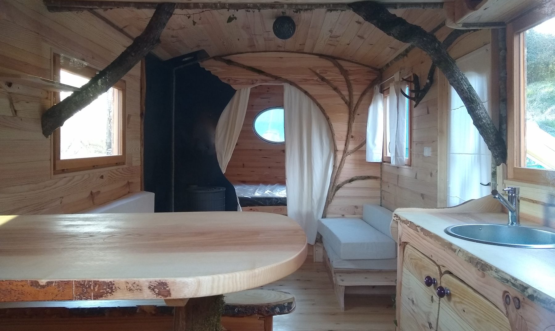 Intérieur roulotte : décor en bois sculpté et coin repas